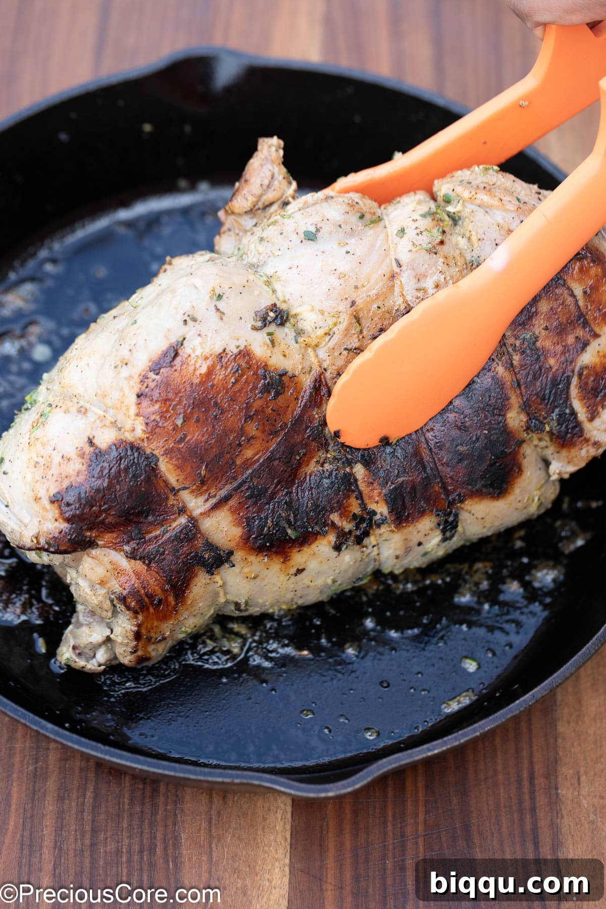 Searing the sides of the boneless lamb leg to ensure even browning and flavor.