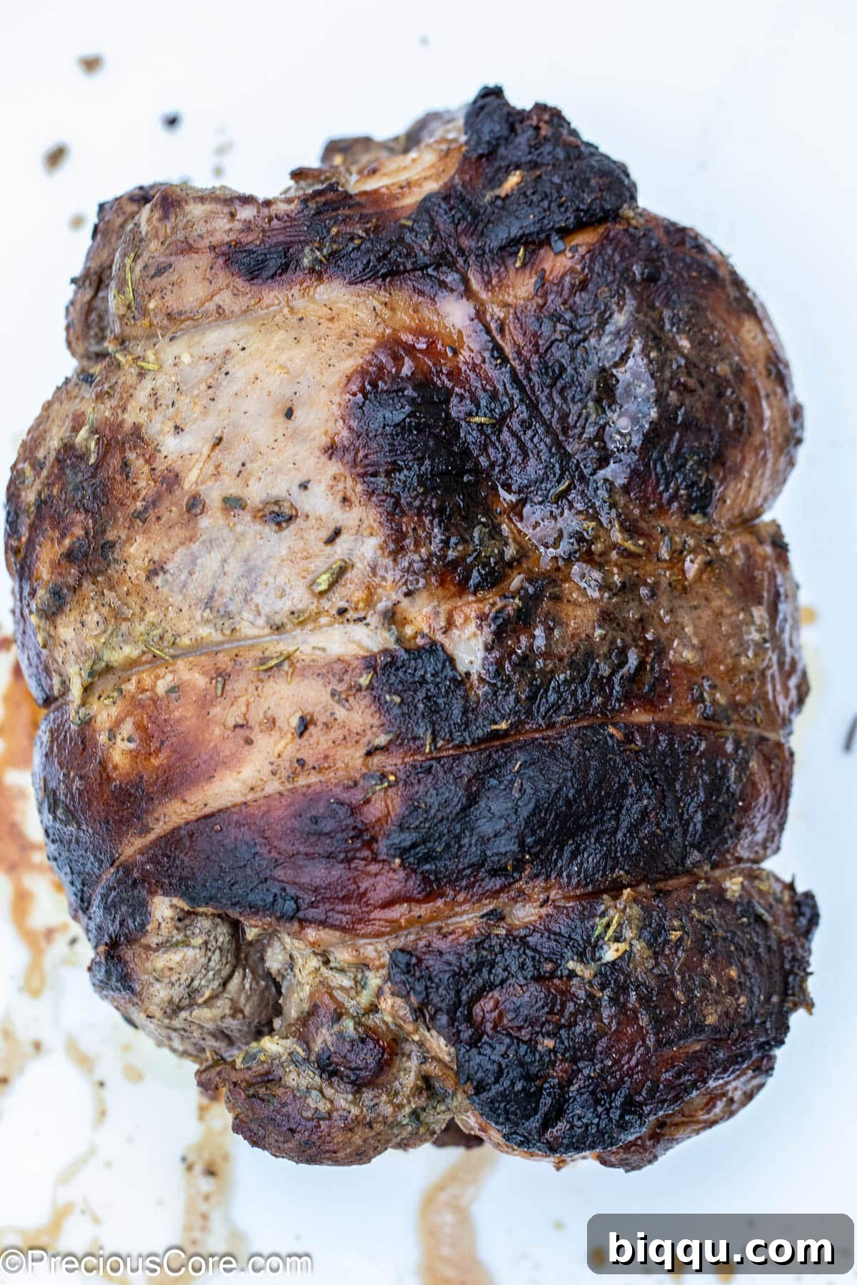 A whole roasted boneless leg of lamb, fresh out of the oven, with a crispy exterior.