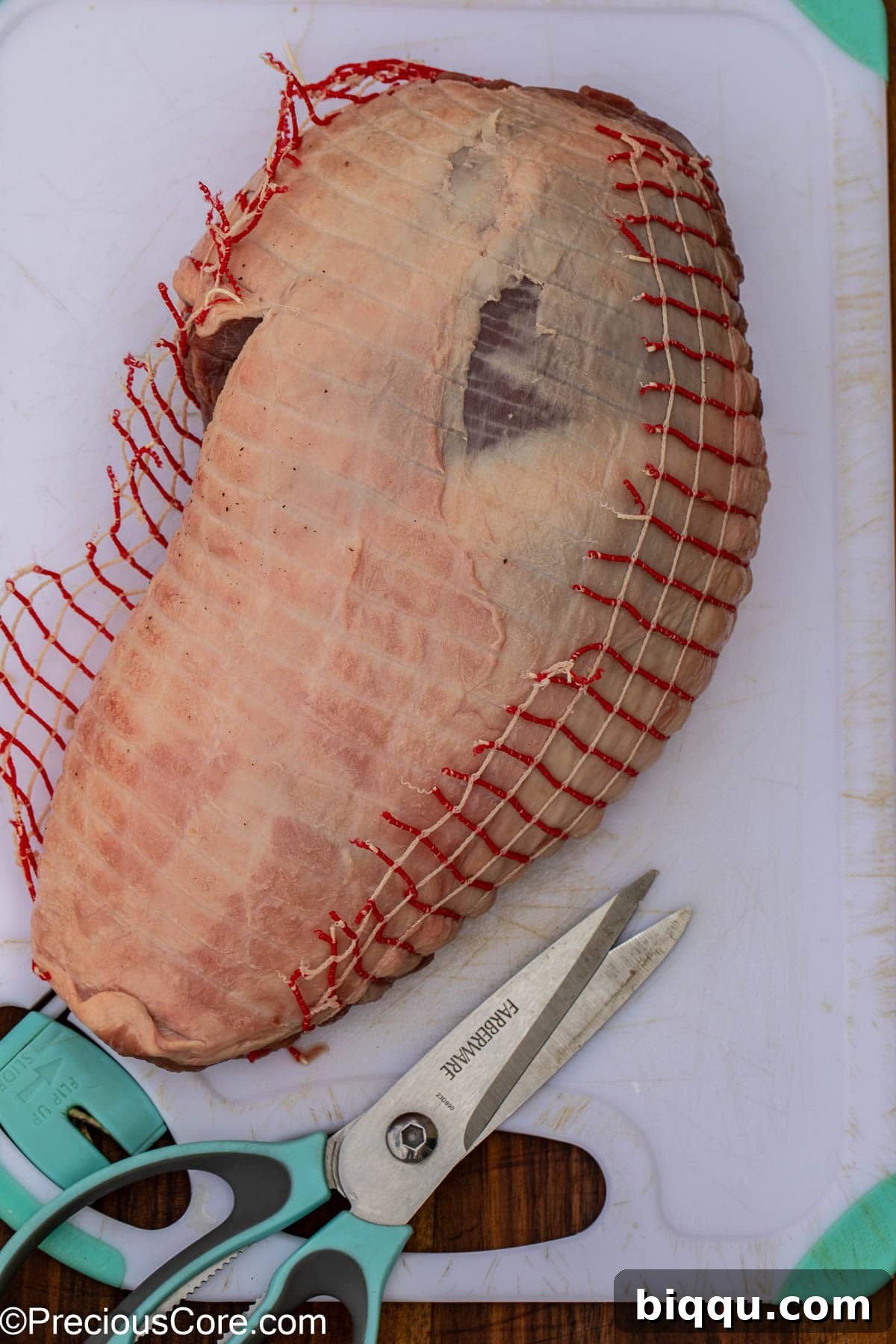 The process of removing netting from the roast package before butterflying.