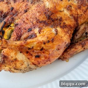 Herb Roasted Duck on a white serving tray, garnished with fresh herbs and lemon.