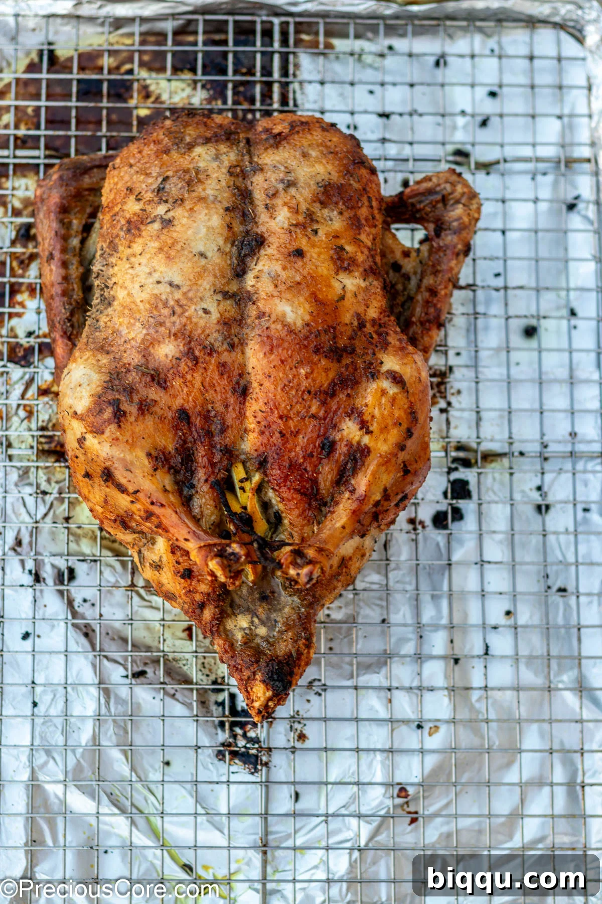 Herb roasted duck on a wire rack in the oven, golden and sizzling.