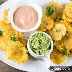 Crispy tostones, or twice-fried plantains, arranged on a serving plate with a sprinkle of seasoning.