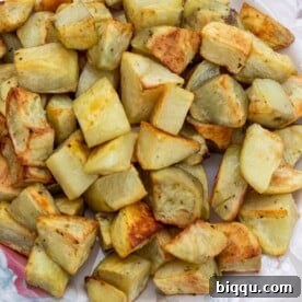 Golden brown roasted potatoes, seasoned to perfection, on a platter.