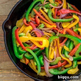Sautéed peppers in a cast iron skillet, bursting with color and flavor.