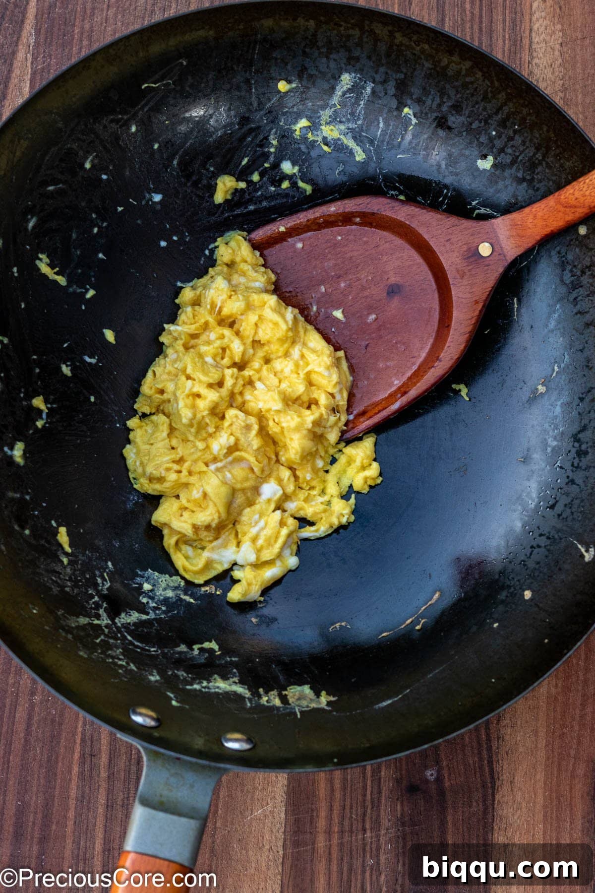 Perfectly scrambled eggs in a wok, ready to be removed.