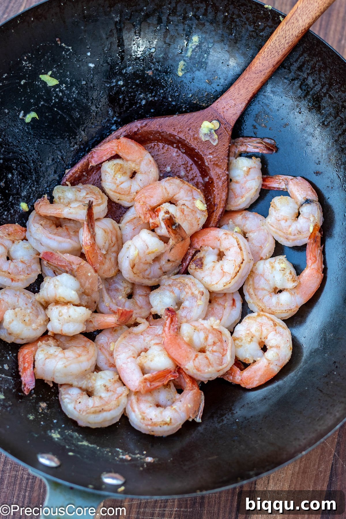 Succulent cooked shrimp in a wok, showing a vibrant pink color.