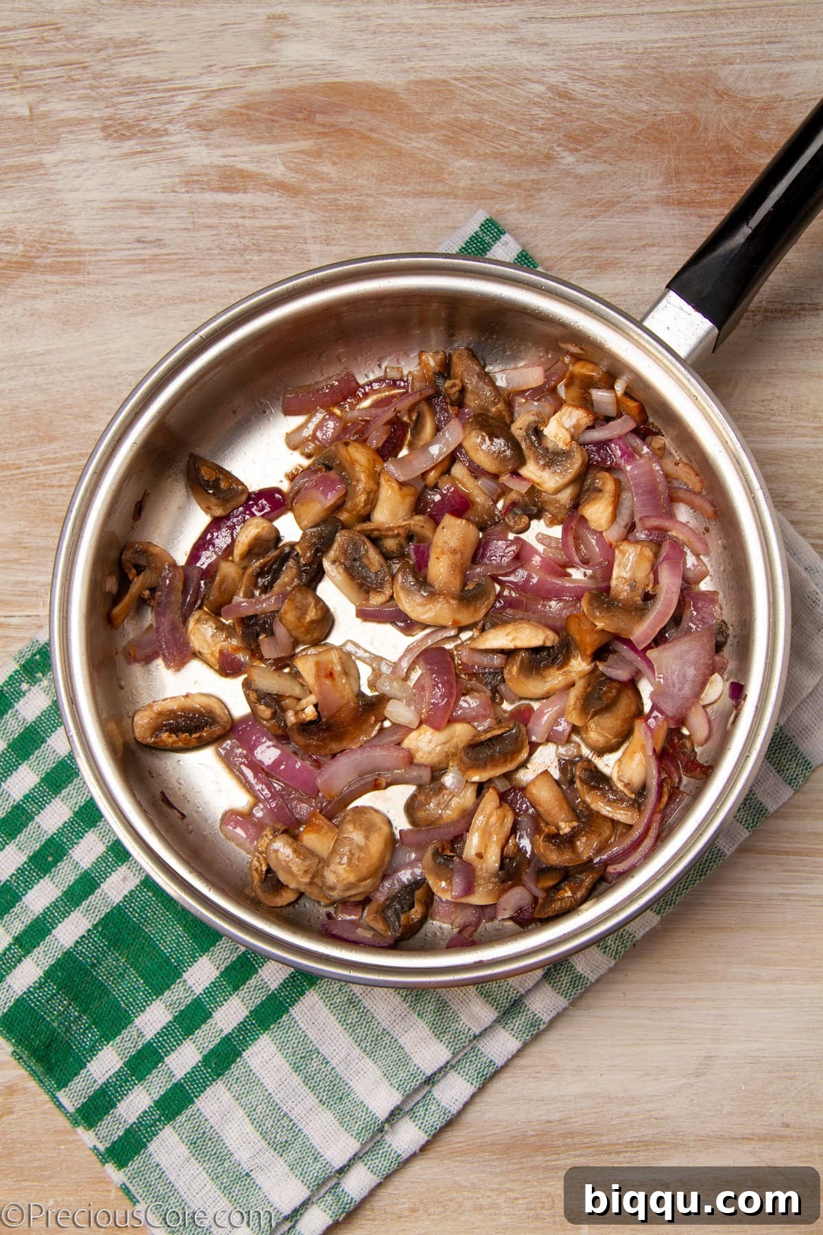 Onions and mushrooms in a pan.