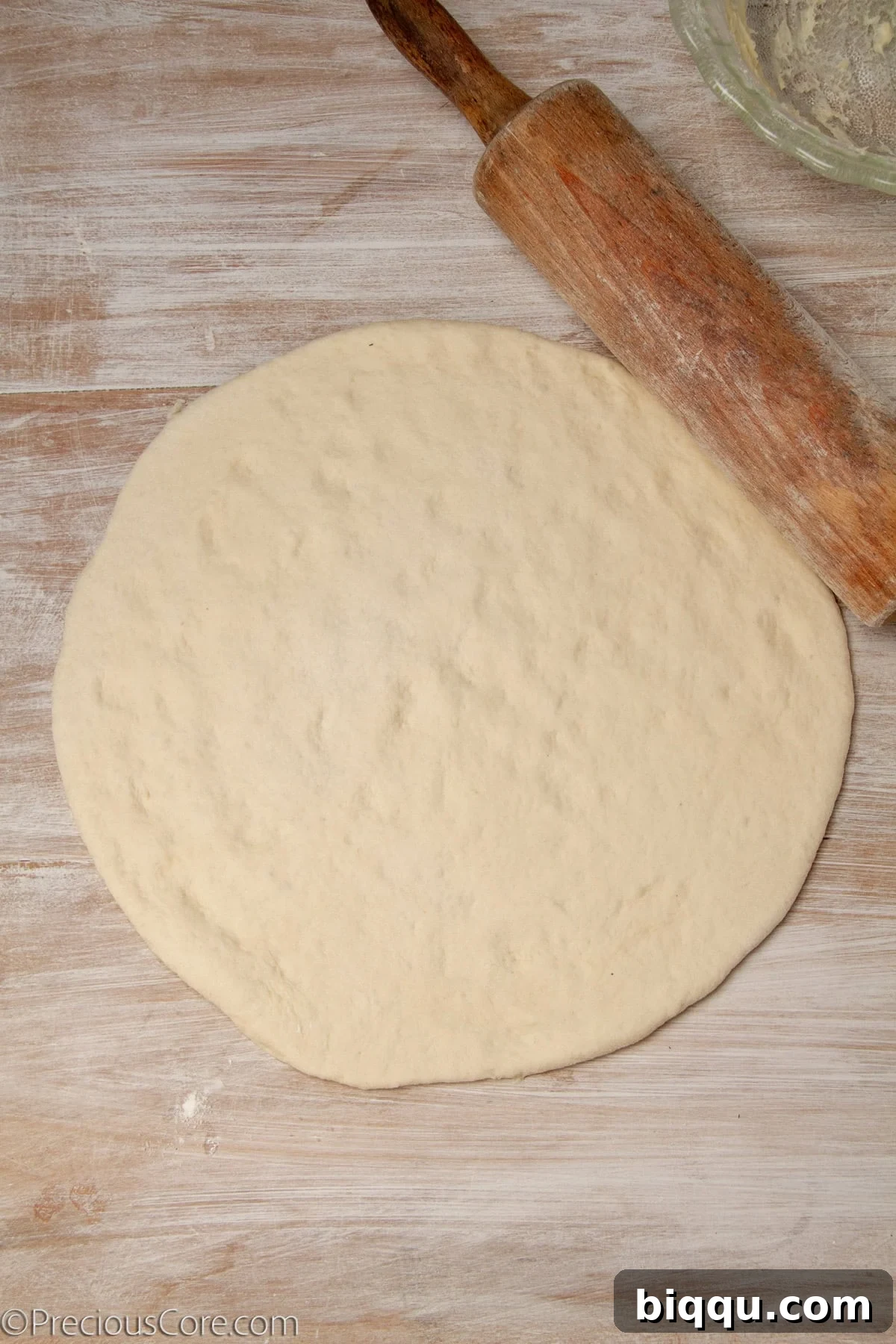 Pizza dough rolled out to form a large circle.