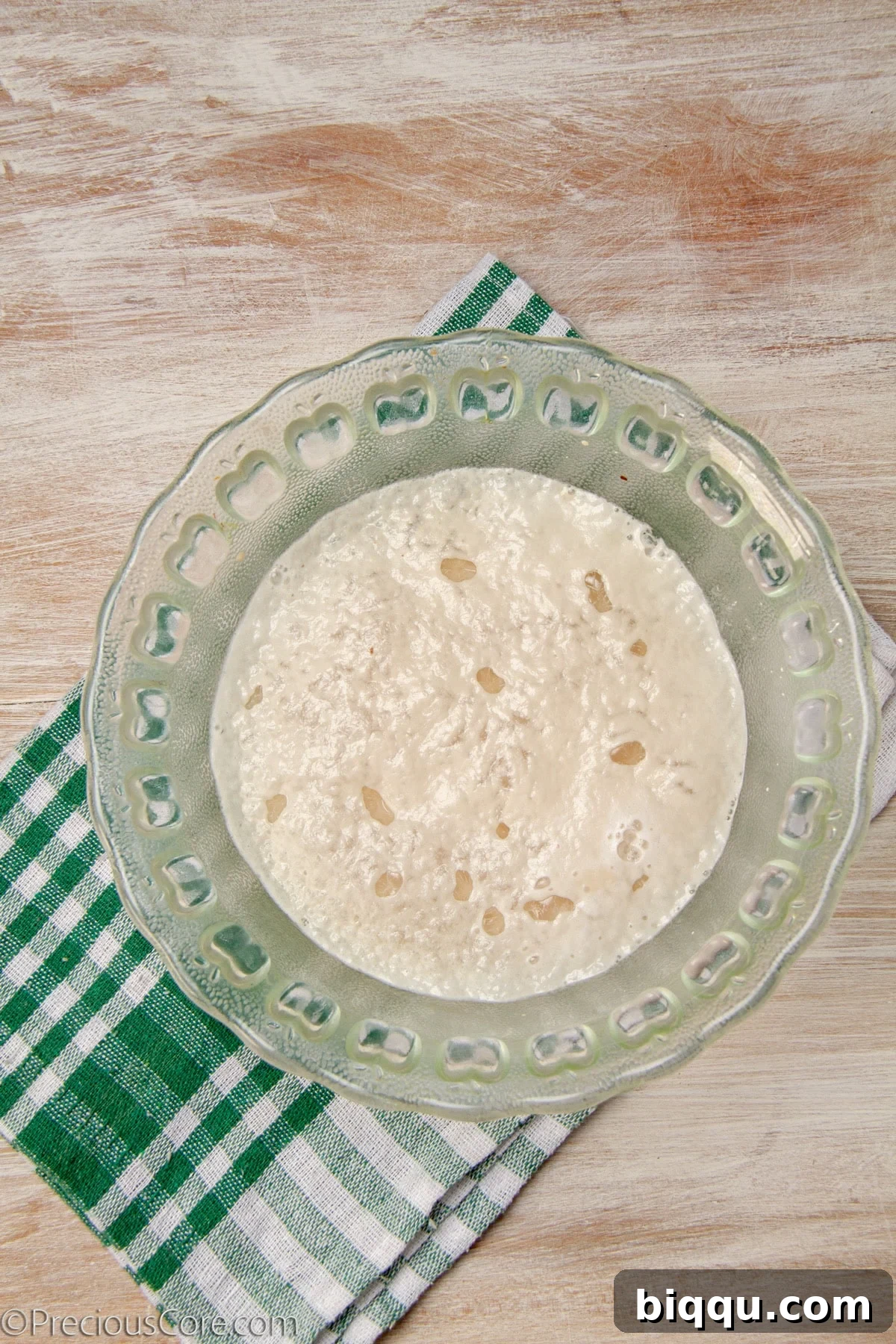 Frothy water and yeast mixture in a bowl.