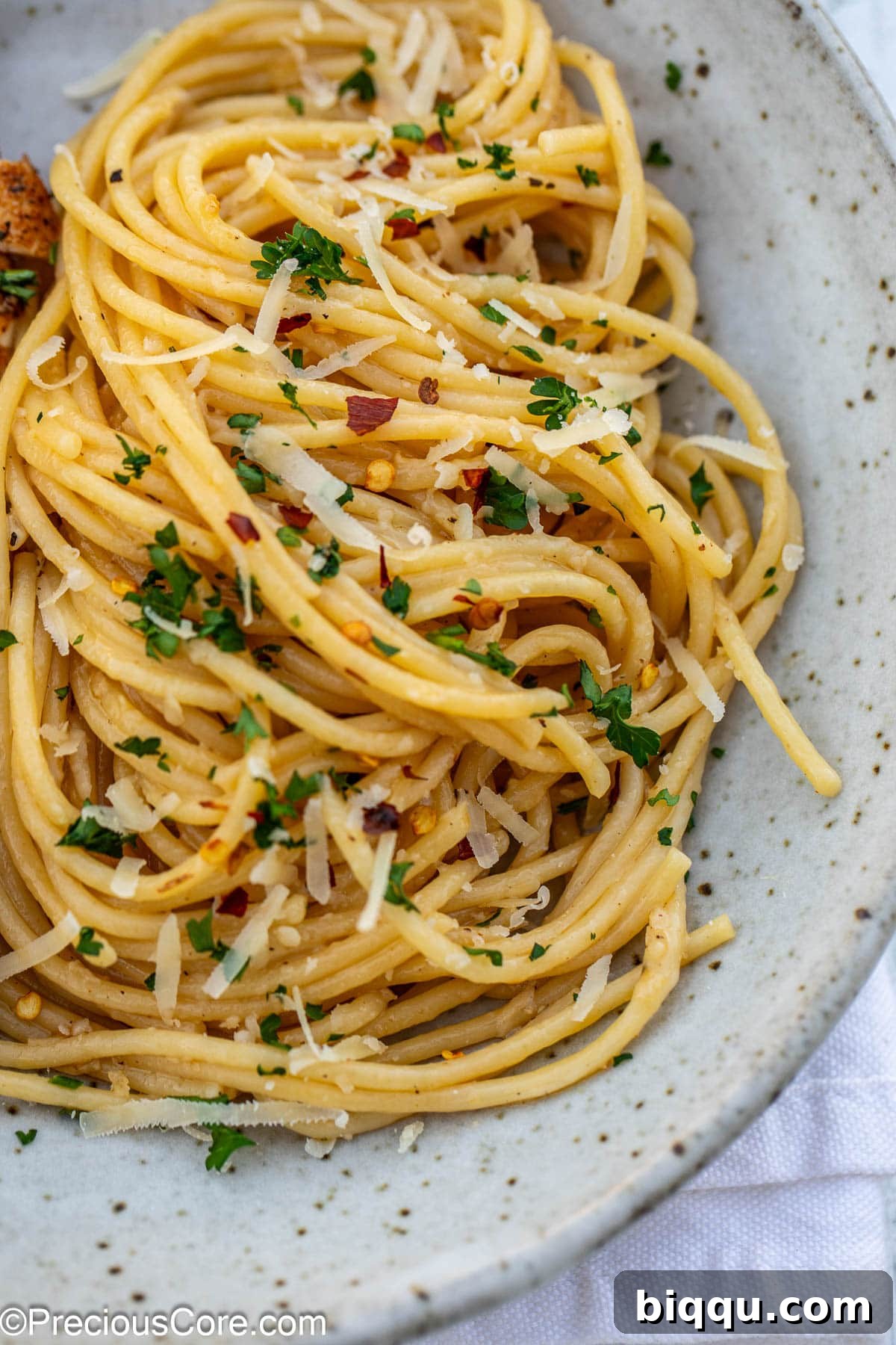 A pristine white pasta bowl brimming with fluffy, golden garlic butter pasta, ready to be enjoyed.