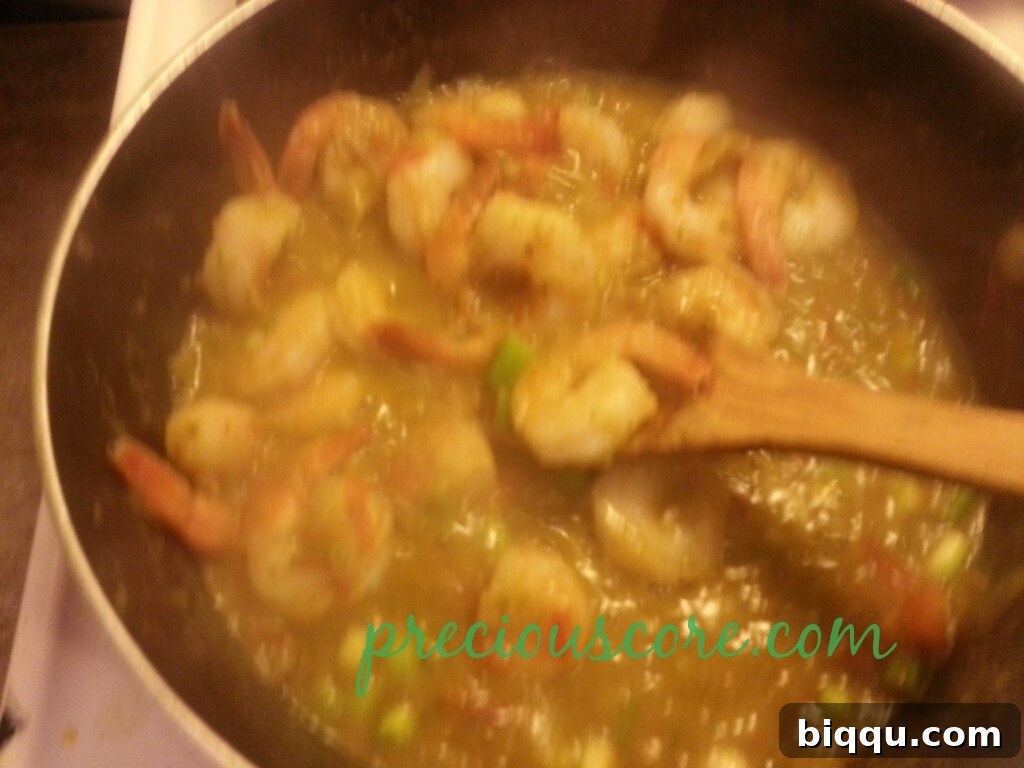 Mixing All Ingredients for a Harmonious Blend Stirring the vegetables and shrimps together in the pan.