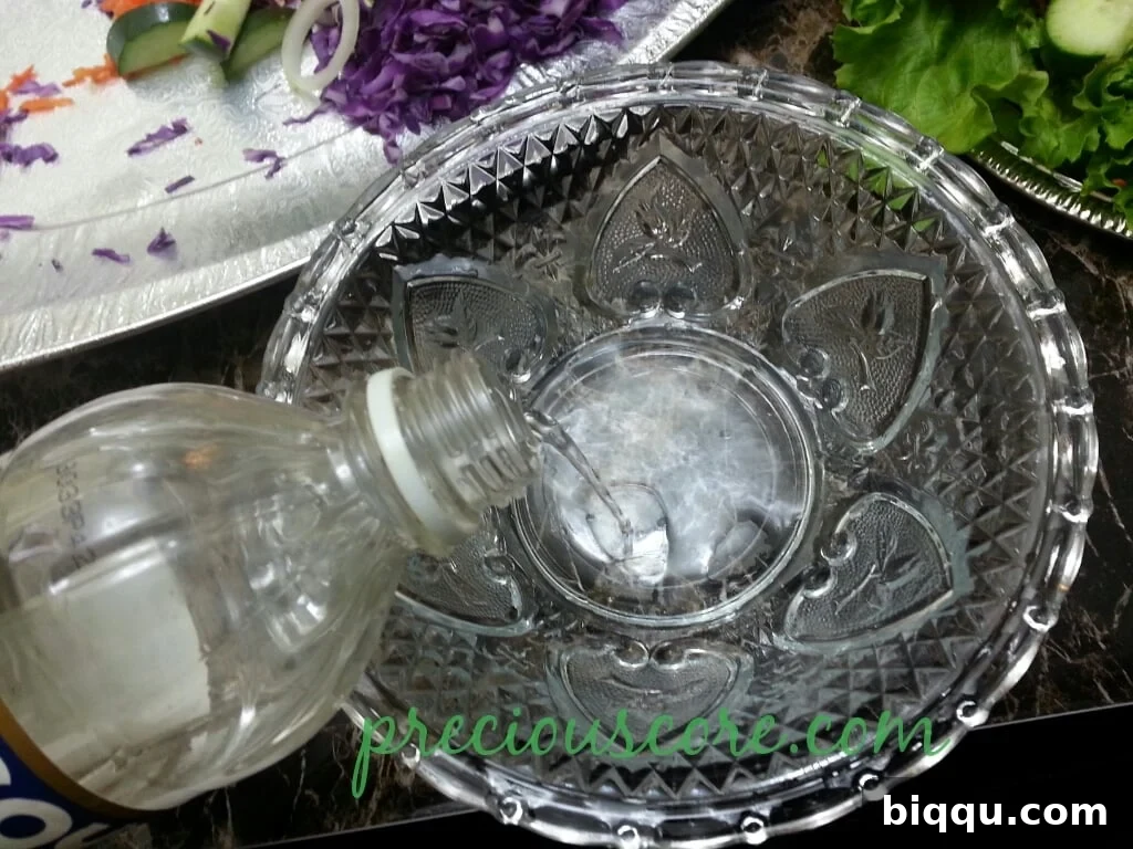 White vinegar poured into a bowl, forming the tangy base for the salad dressing
