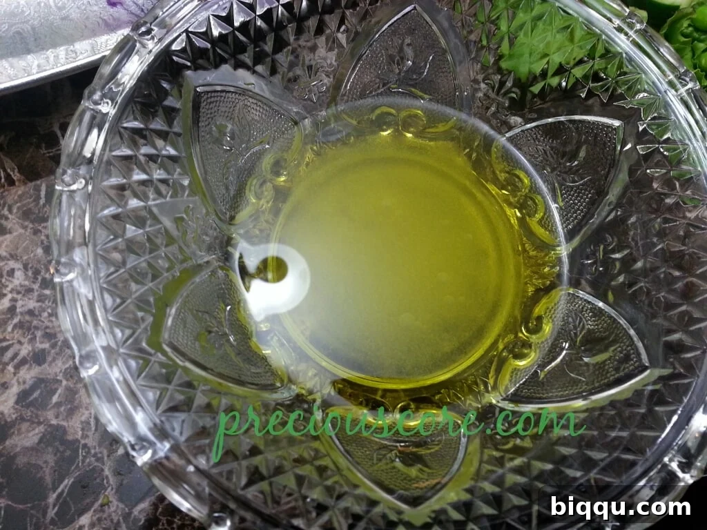 Vegetable oil carefully poured into the bowl with vinegar, sugar, and salt for the dressing