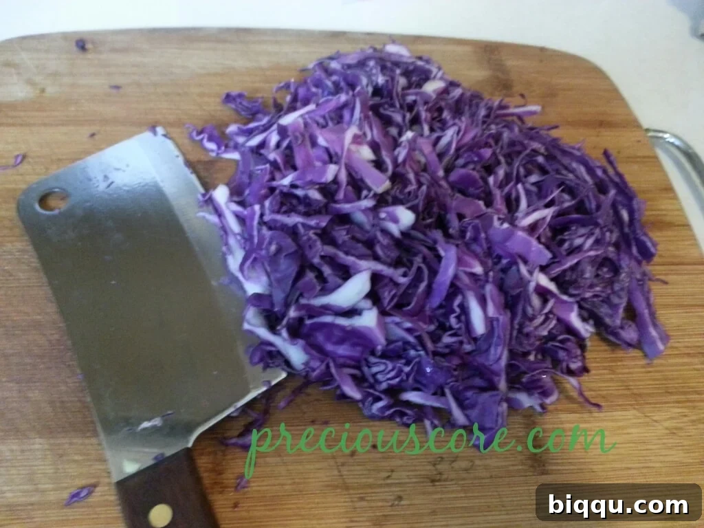 Finely chopped red cabbage, vibrant and fresh, ready for layering in a salad