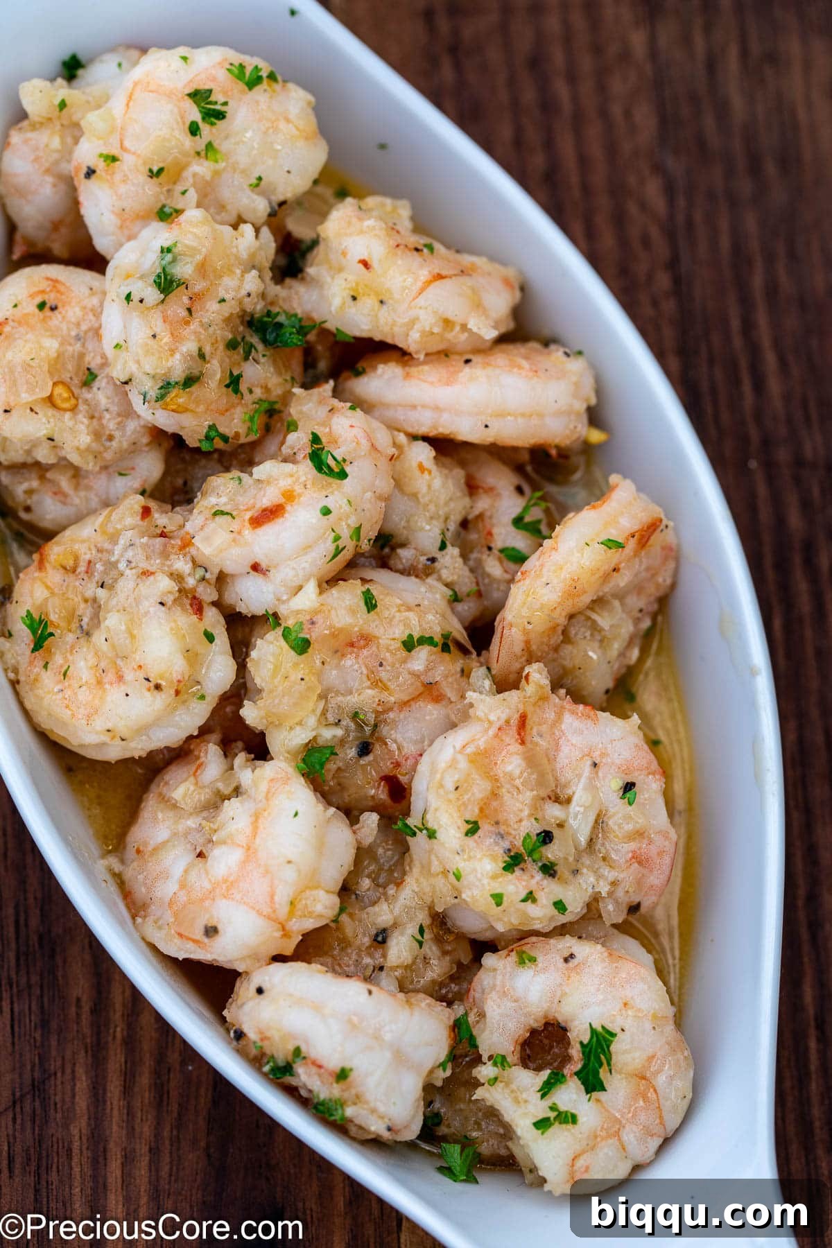 Shrimp in white wine sauce served elegantly in a small white bowl, ready to be enjoyed.