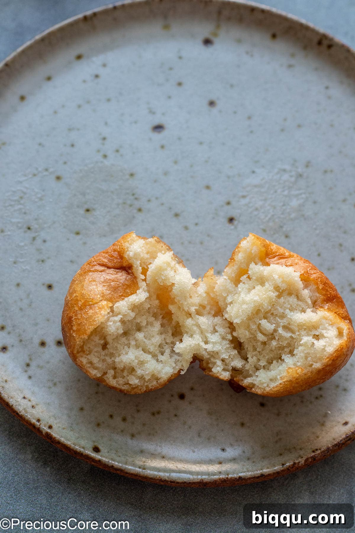 A Puff Puff ball cut open to display its perfectly airy, light, and fluffy interior texture, a hallmark of a well-made fried dough.