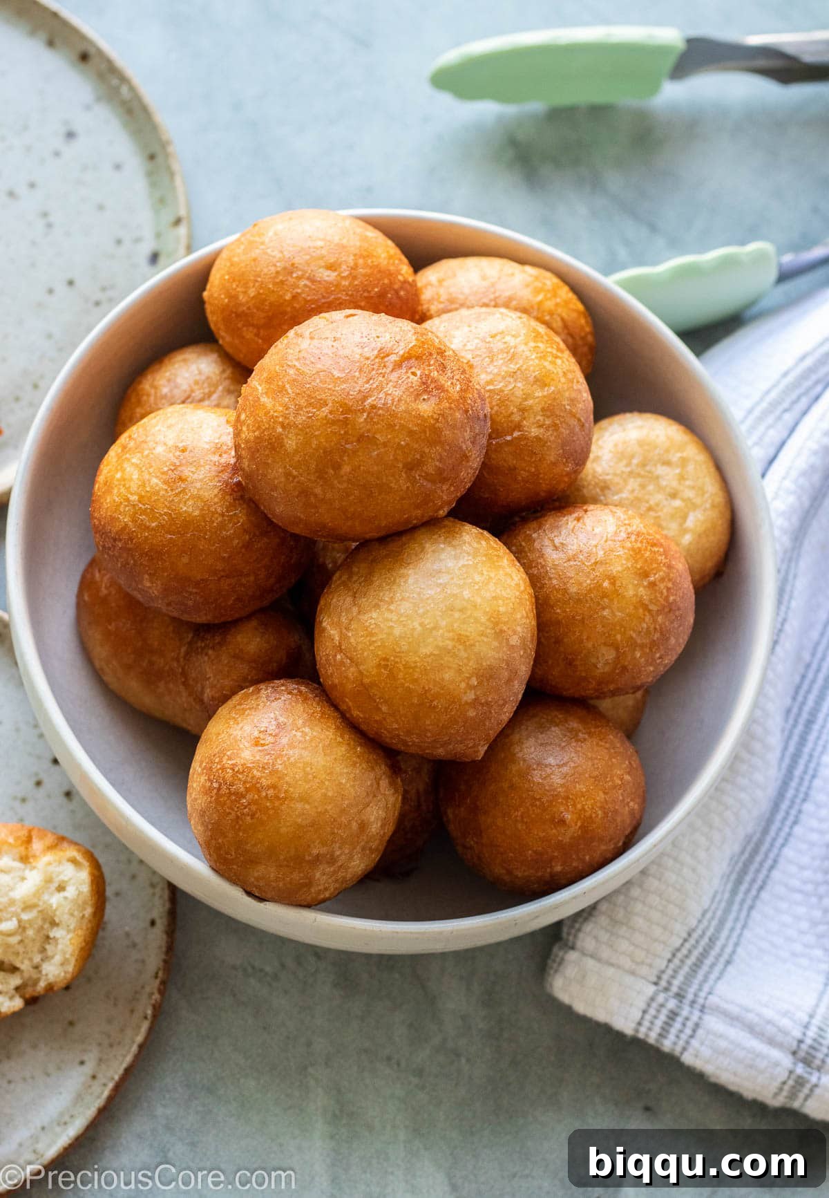 A generous pile of golden-brown Puff Puff balls, perfectly cooked and lightly dusted, filling a white bowl.
