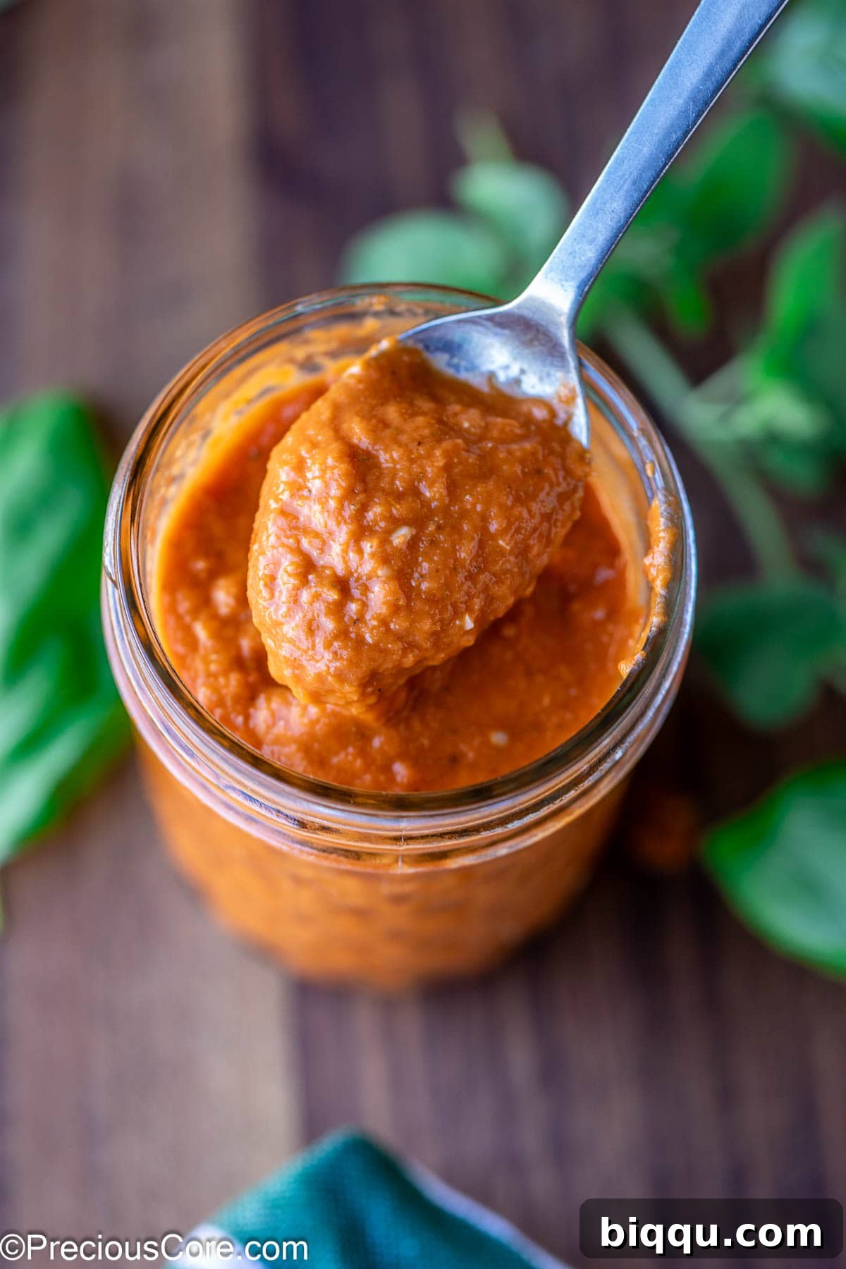 Close-up of vibrant red pizza sauce made with roasted tomatoes, ready to be spread on pizza dough.