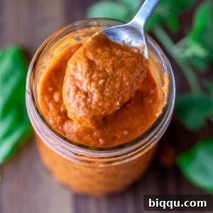 Close-up of vibrant red pizza sauce made with roasted tomatoes.