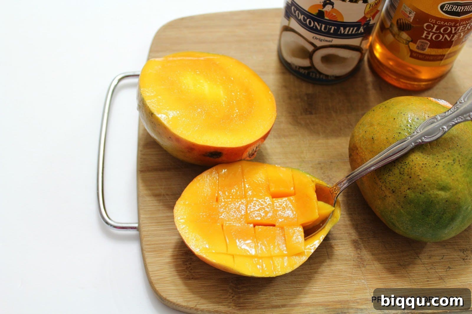Scooping out mango flesh with a spoon