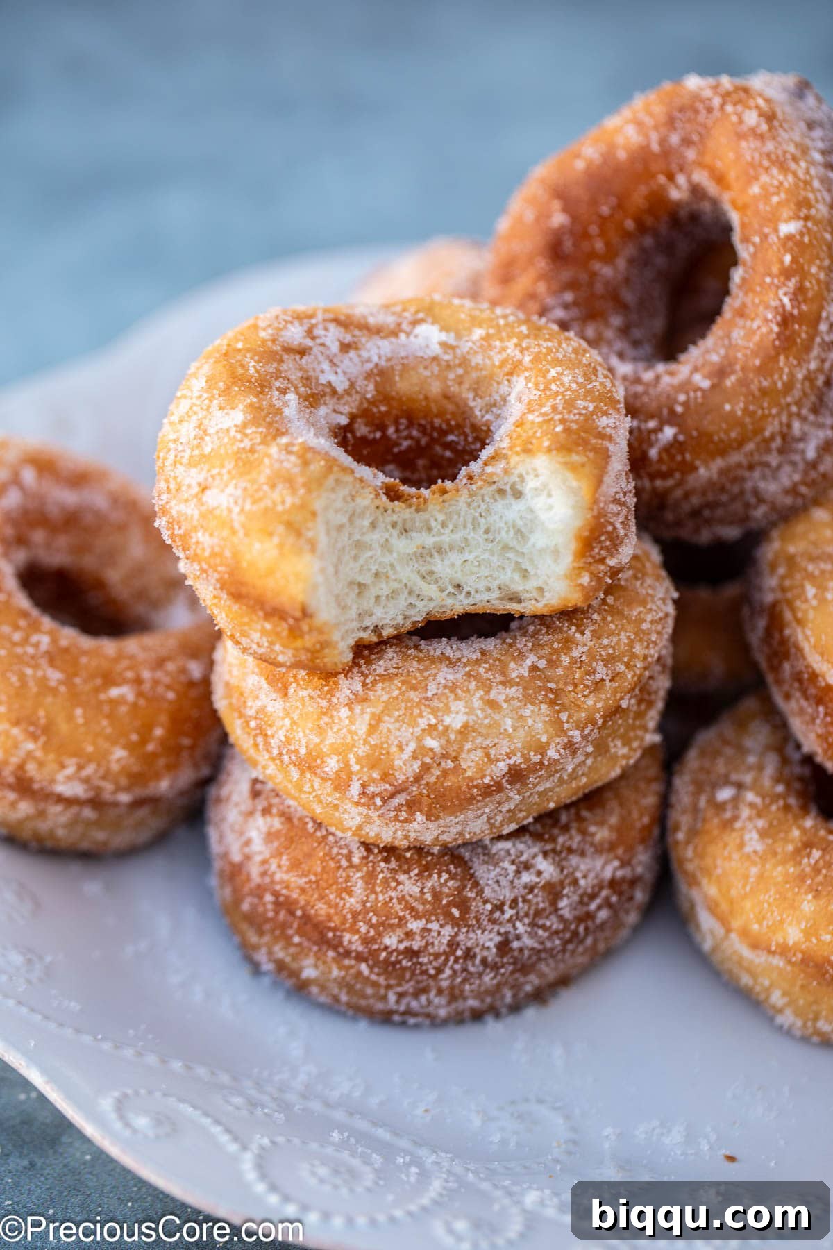 Stack of doughnuts with one missing a bite.