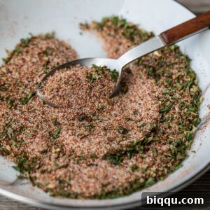 A spoon grabbing some of the best seasoning for French fries, ready to be sprinkled.
