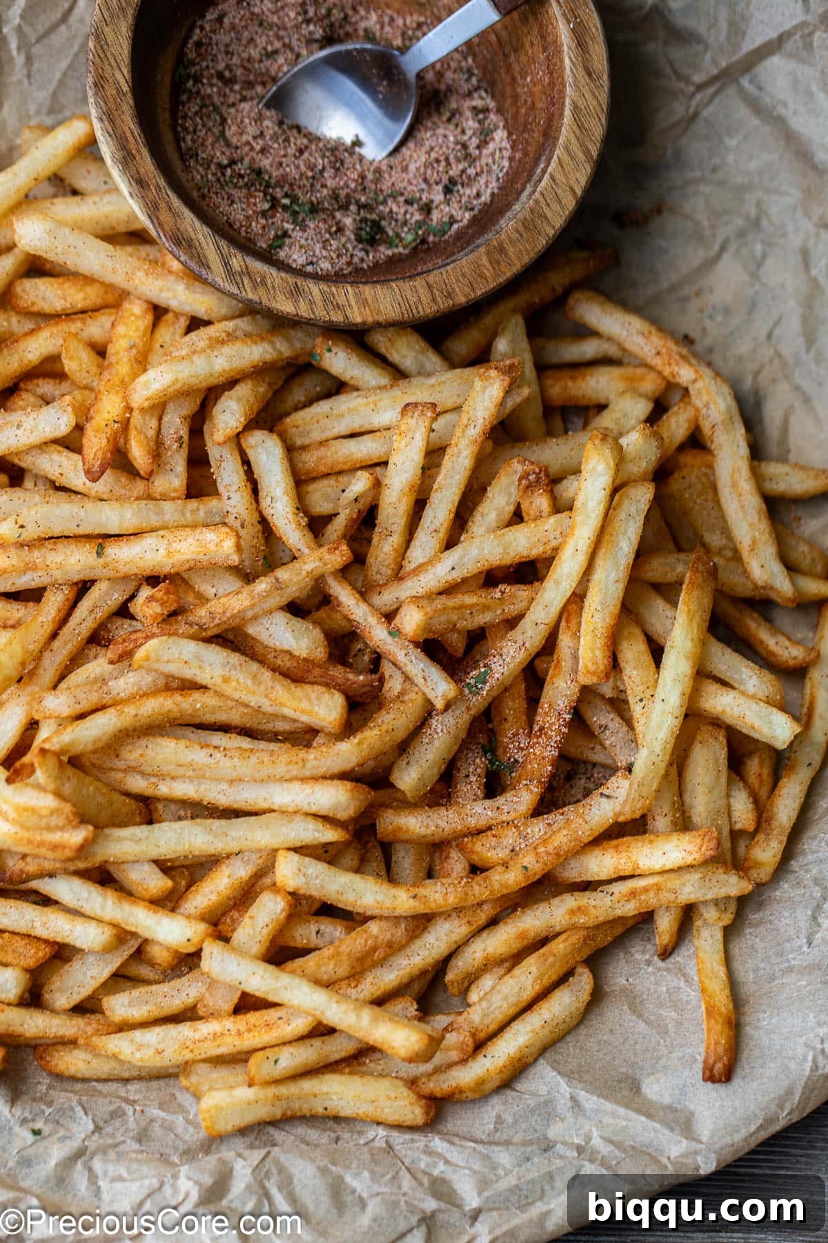Close-up shot of perfectly golden, seasoned French fries, ready to be enjoyed.