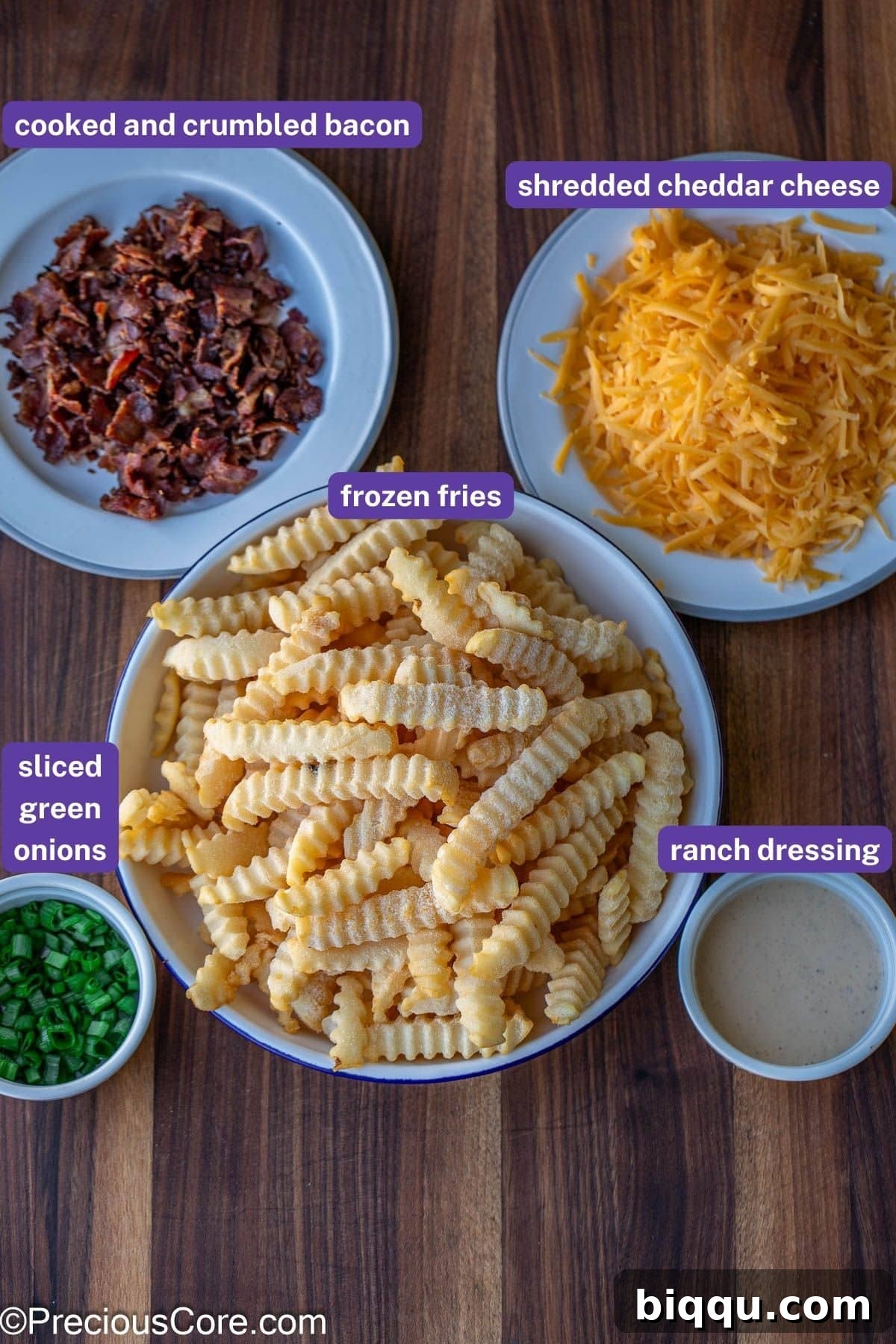 Labeled ingredients for loaded fries: frozen french fries, shredded cheddar cheese, cooked and crumbled bacon, ranch dressing, and sliced green onions.