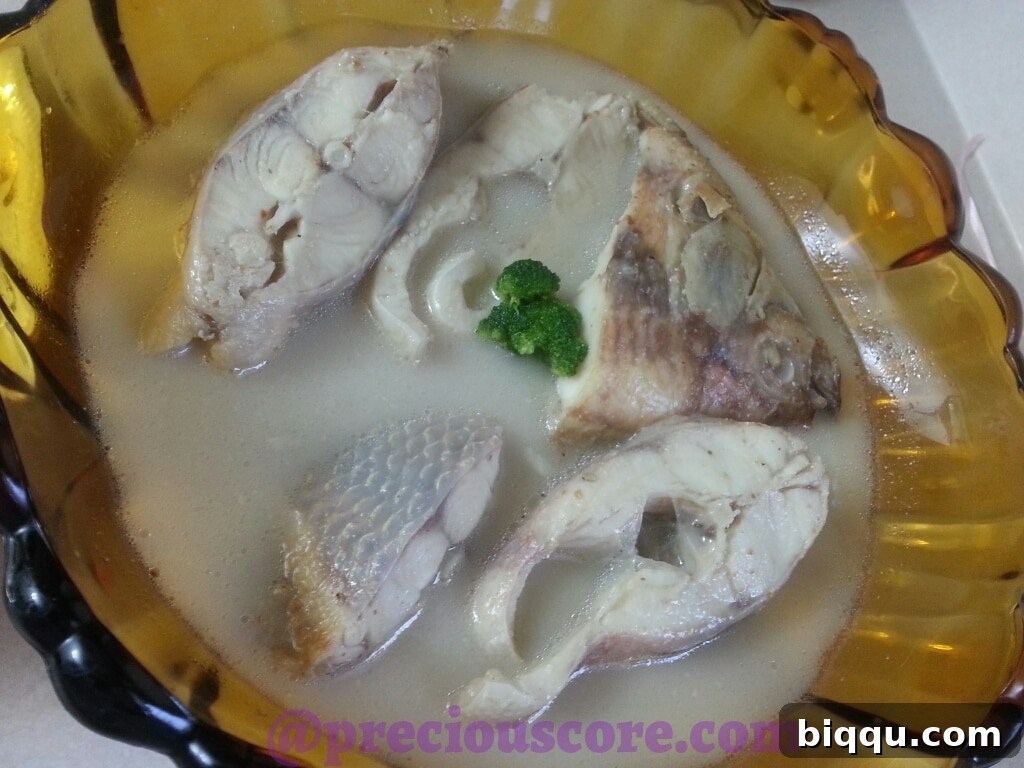 Fresh ingredients for Cameroonian Fish Pepper Soup, including fish, spices, and aromatics.