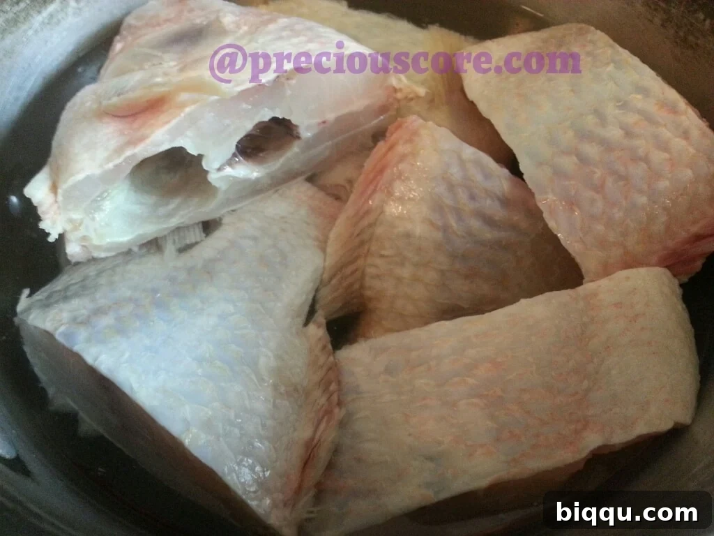 Cleaned fish seasoned and ready in the pot with water.