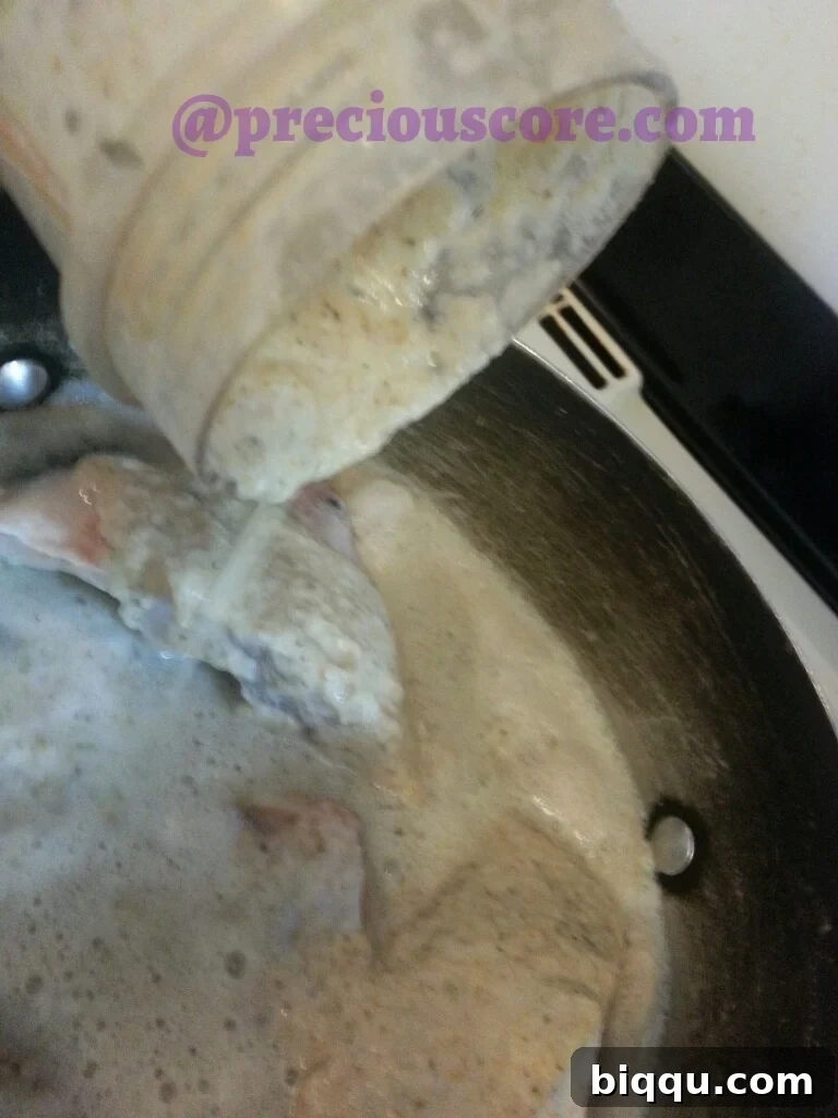 Blended spices and aromatics being added to the pot of fish.