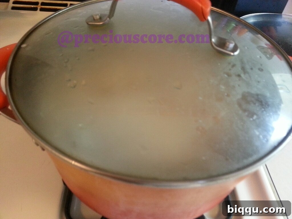 Cameroonian Fish Pepper Soup simmering in a pot on the stove.
