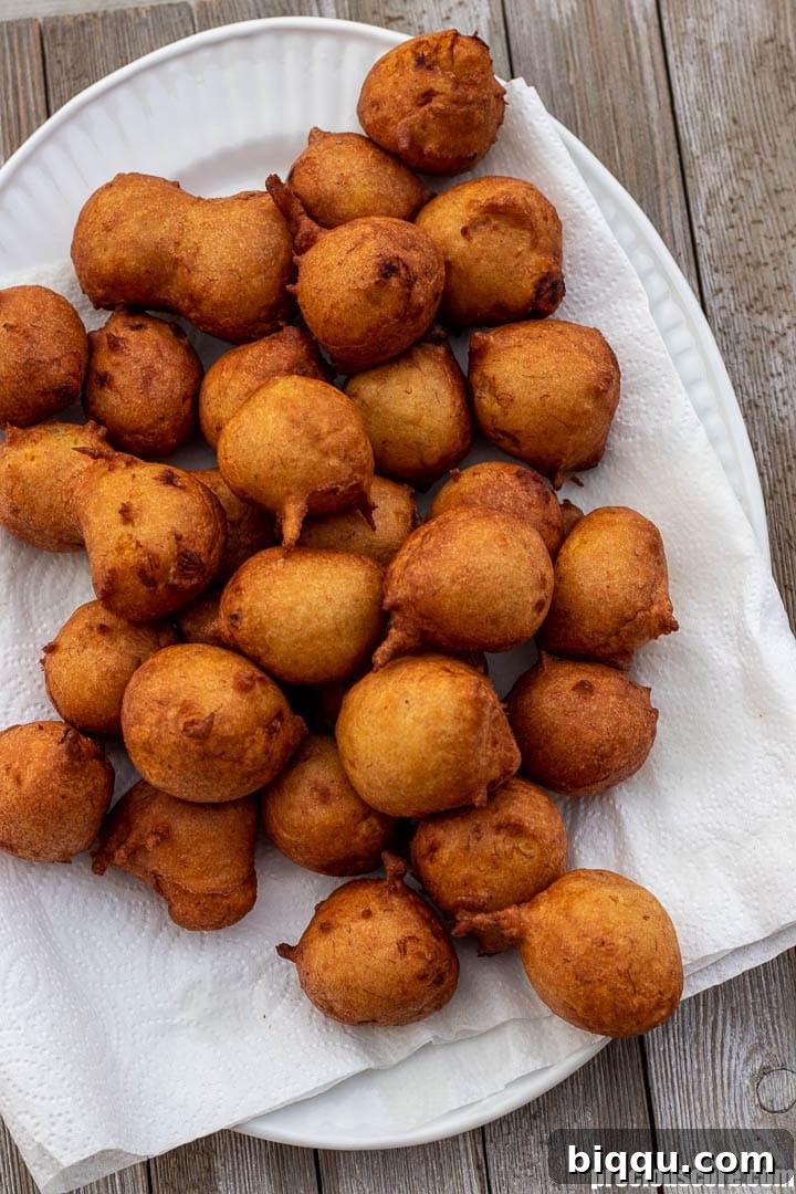 Banana fritters on a platter lined with paper towels.