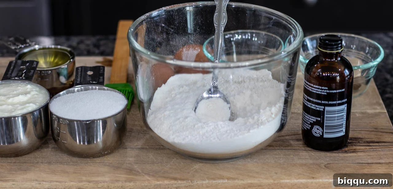 Essential ingredients for baking a yogurt cake laid out on a chopping board.