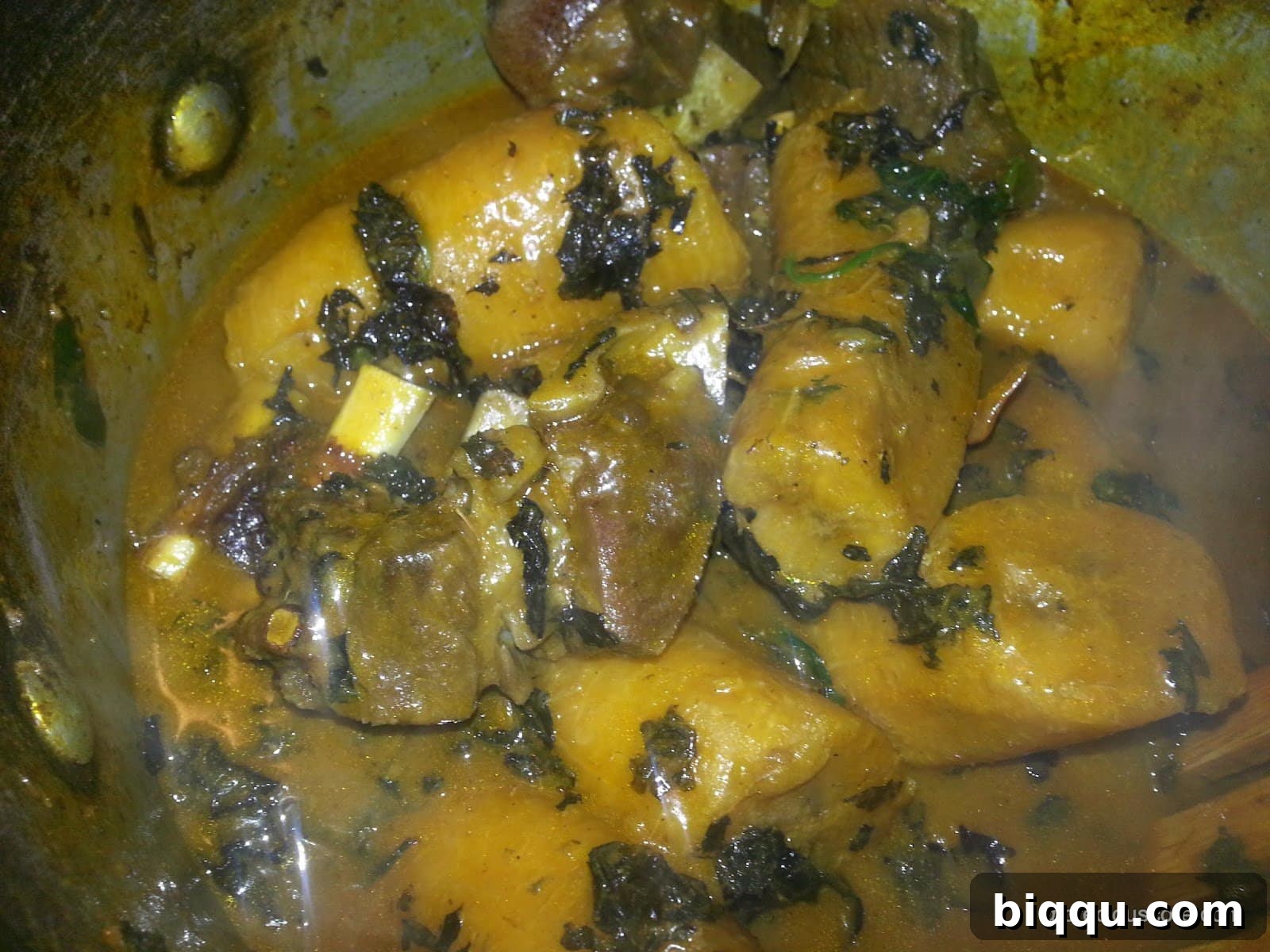 The finished Born House Planti dish, beautifully cooked and ready to be served from the pot, showcasing its rich red color and tender plantains.