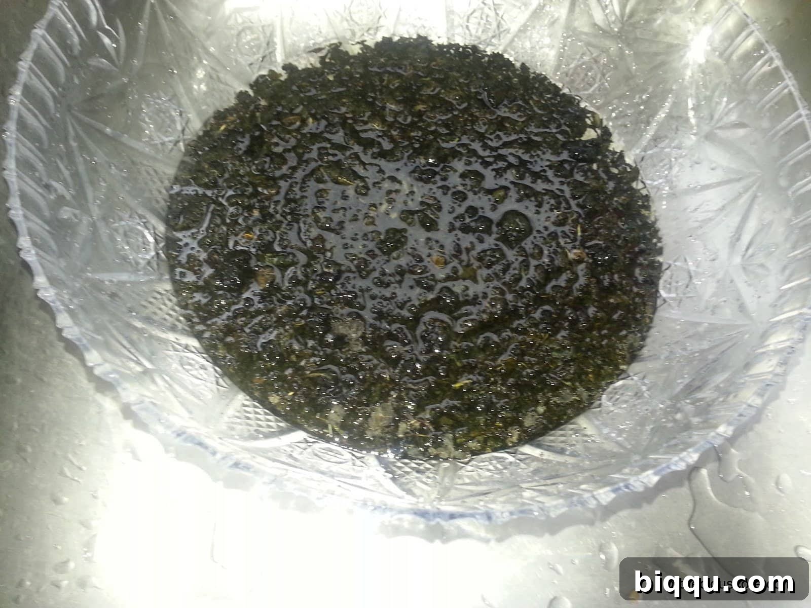 Dried bitterleaves soaking in a bowl of water, preparing them for use in the traditional Cameroonian Born House Planti.