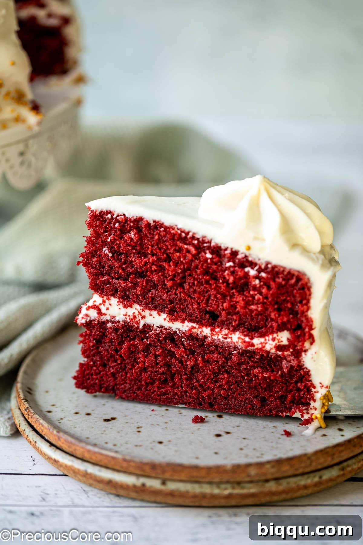 Velvet Dream Cake Without Buttermilk 2 A beautiful slice of red velvet cake on a white plate, showcasing its vibrant red layers and creamy white frosting.
