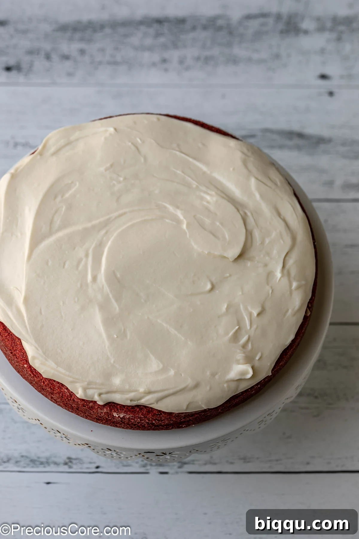 Velvet Dream Cake Without Buttermilk 13 The first layer of red velvet cake covered with a generous, smooth layer of cream cheese frosting.