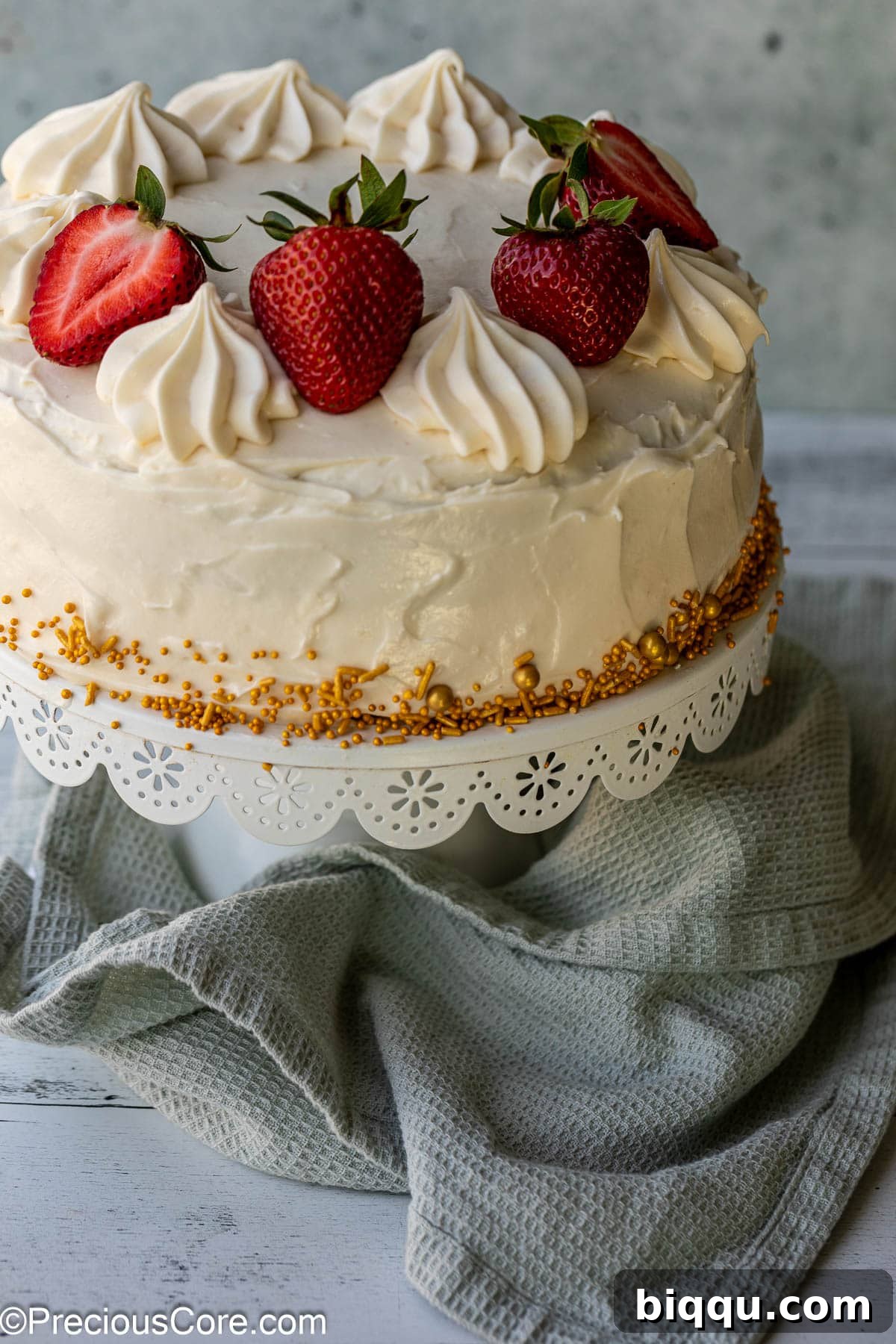 Velvet Dream Cake Without Buttermilk 3 A perfectly frosted red velvet cake standing tall on a elegant cake stand, ready to be sliced and served.