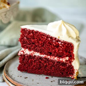 Velvet Dream Cake Without Buttermilk 17 A slice of red velvet cake on a plate, showcasing its vibrant red layers and creamy white frosting.