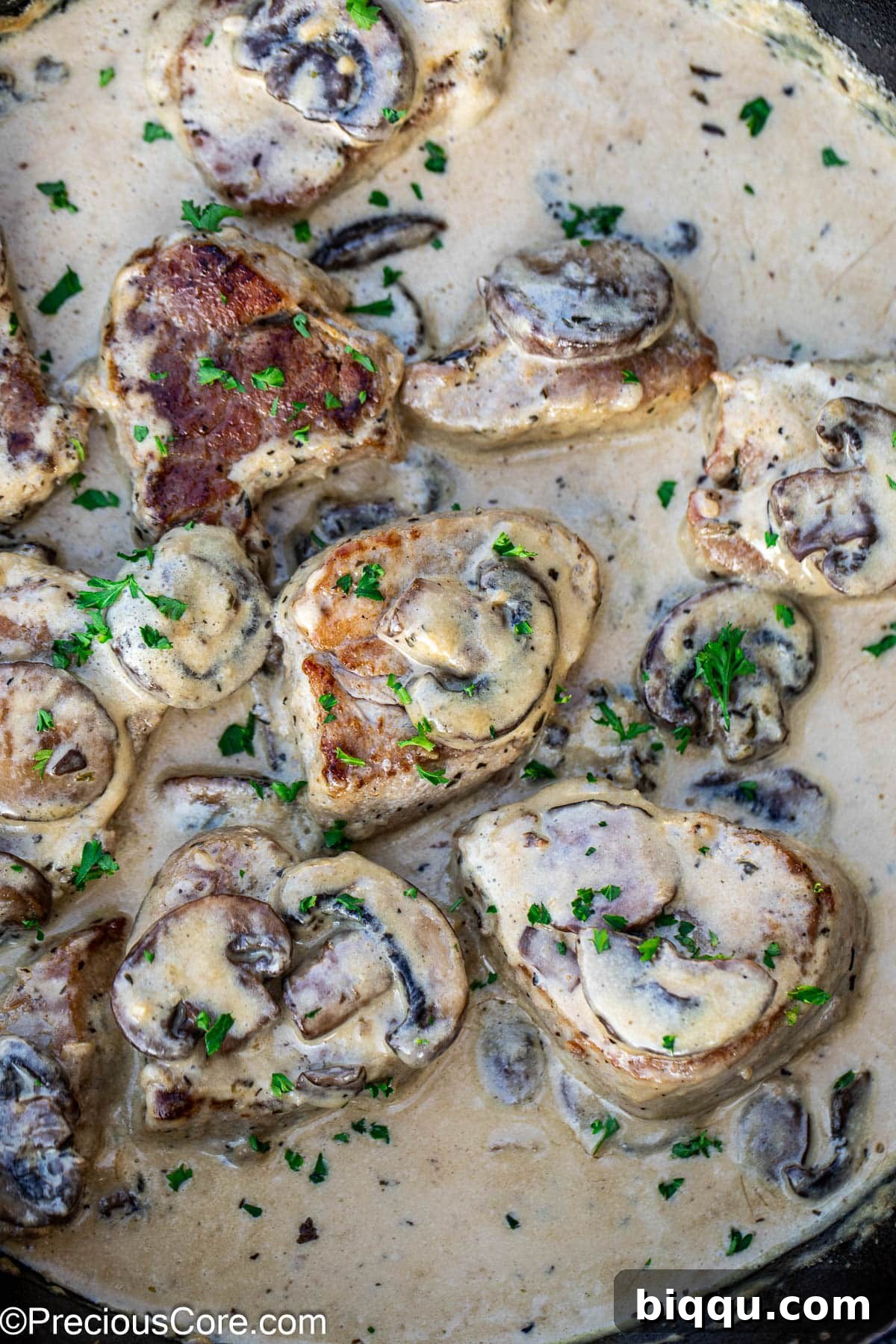Perfectly cooked pork tenderloin medallions generously coated in a luscious, creamy mushroom sauce, ready to be served.