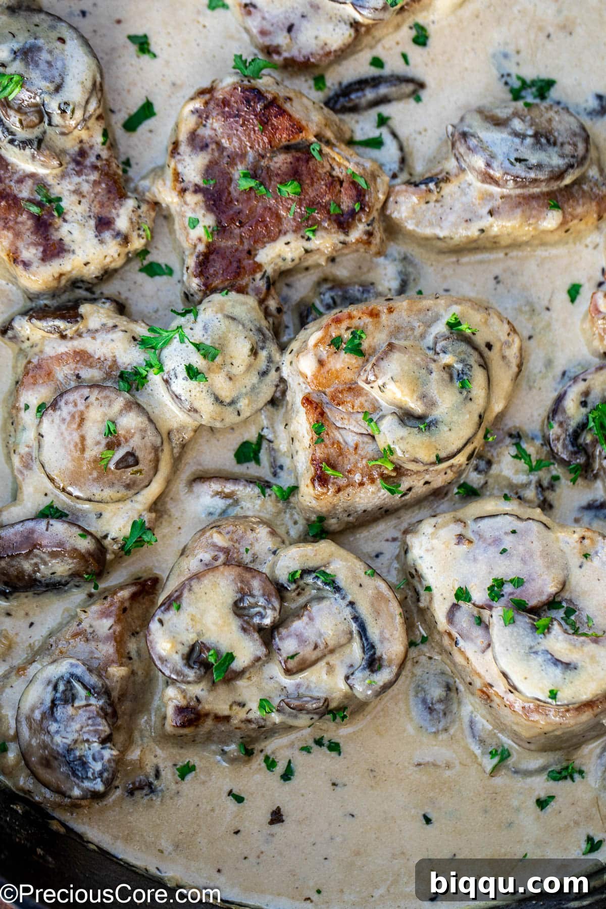 Finished dish of pork medallions topped with sautéed mushrooms and a rich, savory creamy sauce, ready to be enjoyed.