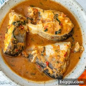 A bowl with three steaks of catfish in pepper soup.