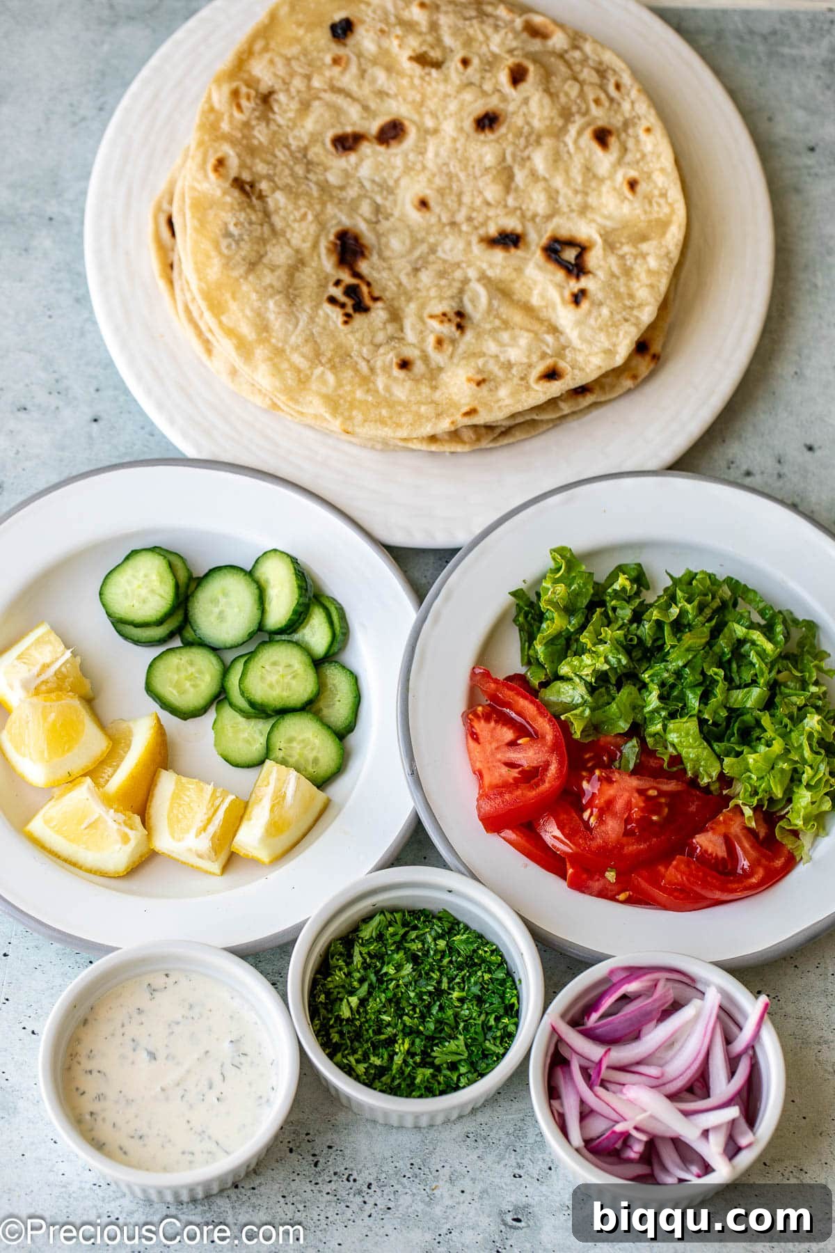 A vibrant selection of fresh ingredients like crisp lettuce, ripe tomatoes, and seasoned meat, suggesting the components for building a delicious shawarma wrap or bowl.