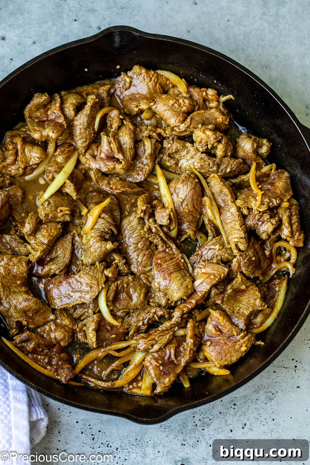 Cooking marinated beef shawarma in a skillet.