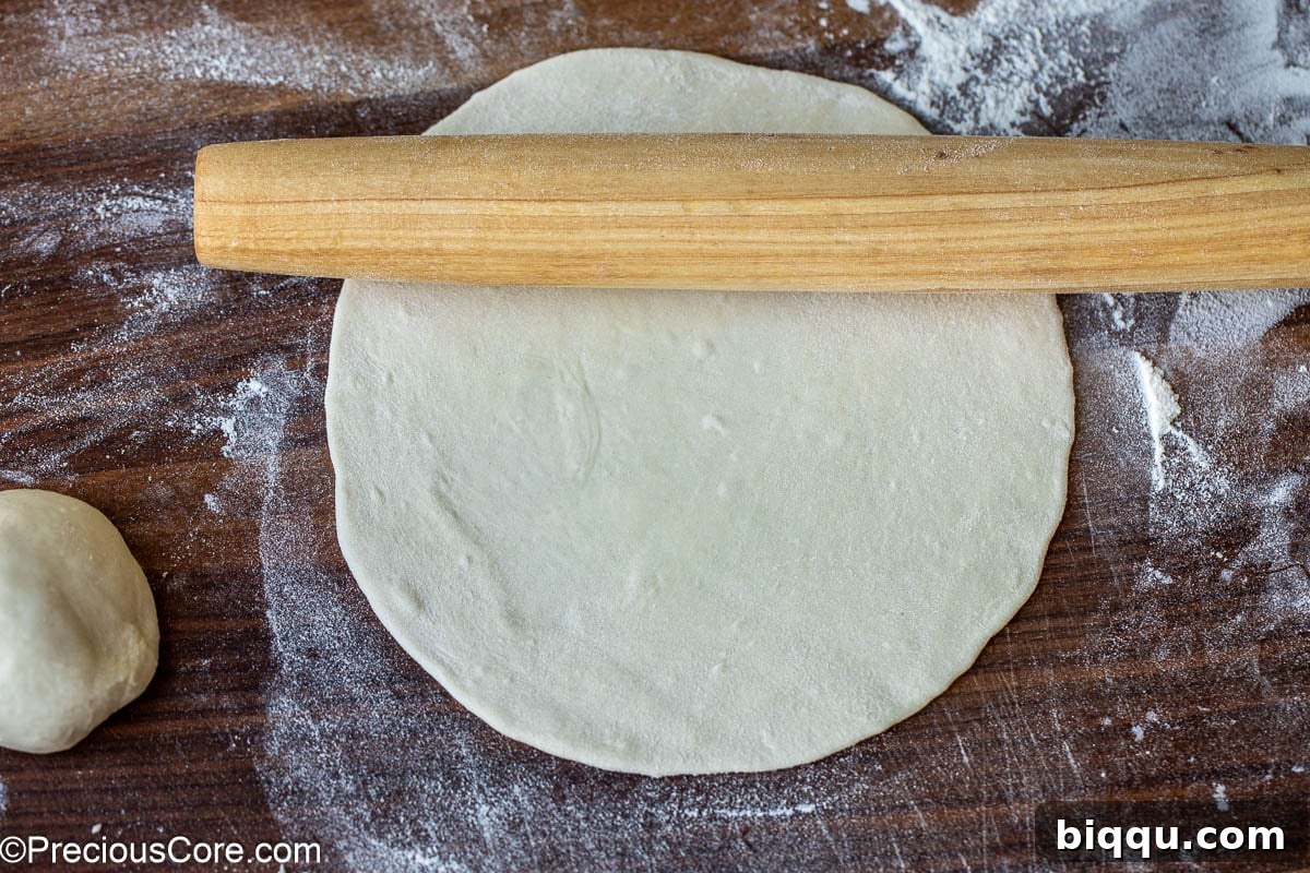 Golden Shawarma Wraps 9 Rolling pin on rolled out dough on a floured surface.