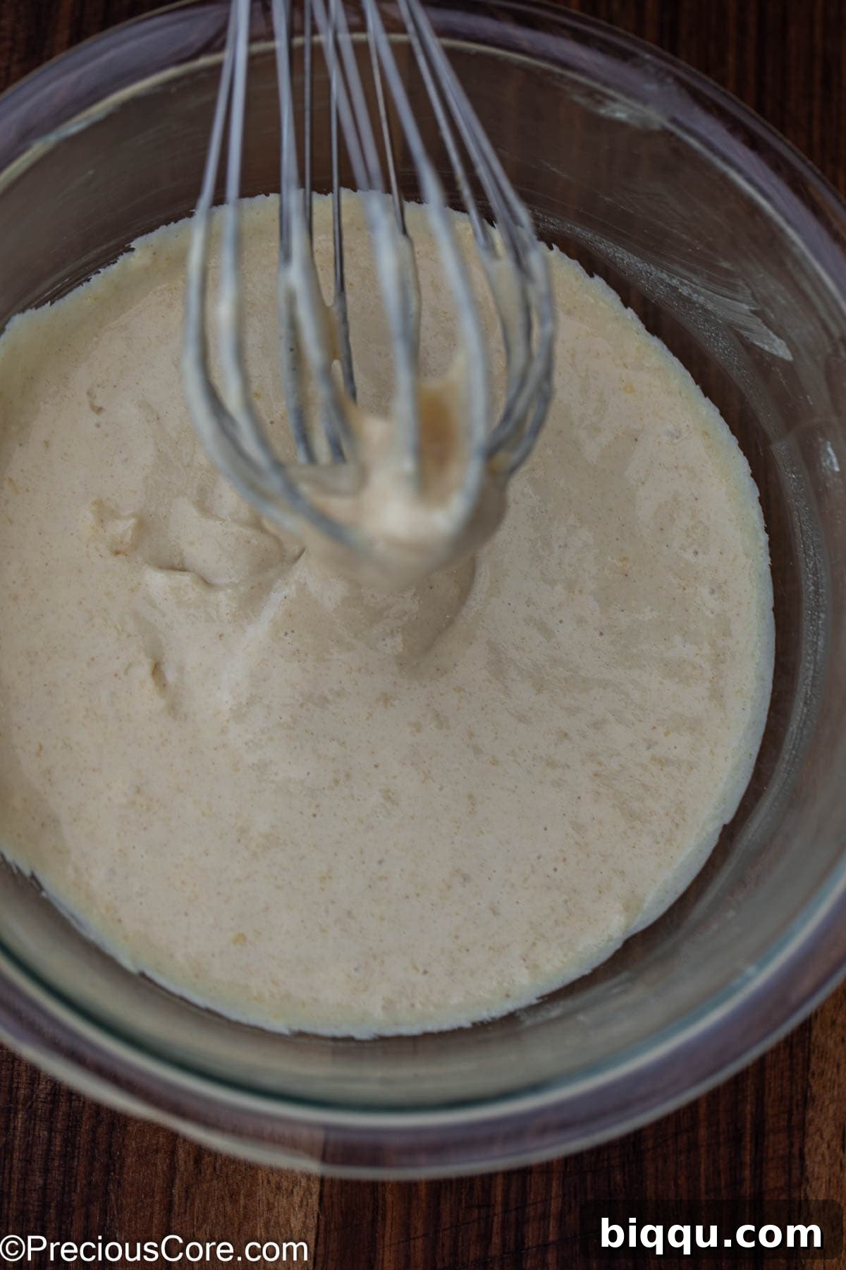 Pancake batter being mixed in a bowl with a whisk.