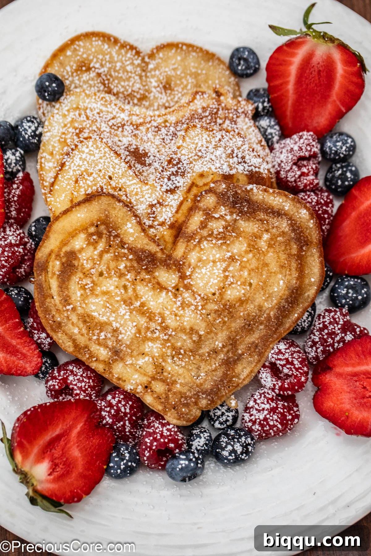 A stack of perfectly golden heart-shaped pancakes, ready to be topped.
