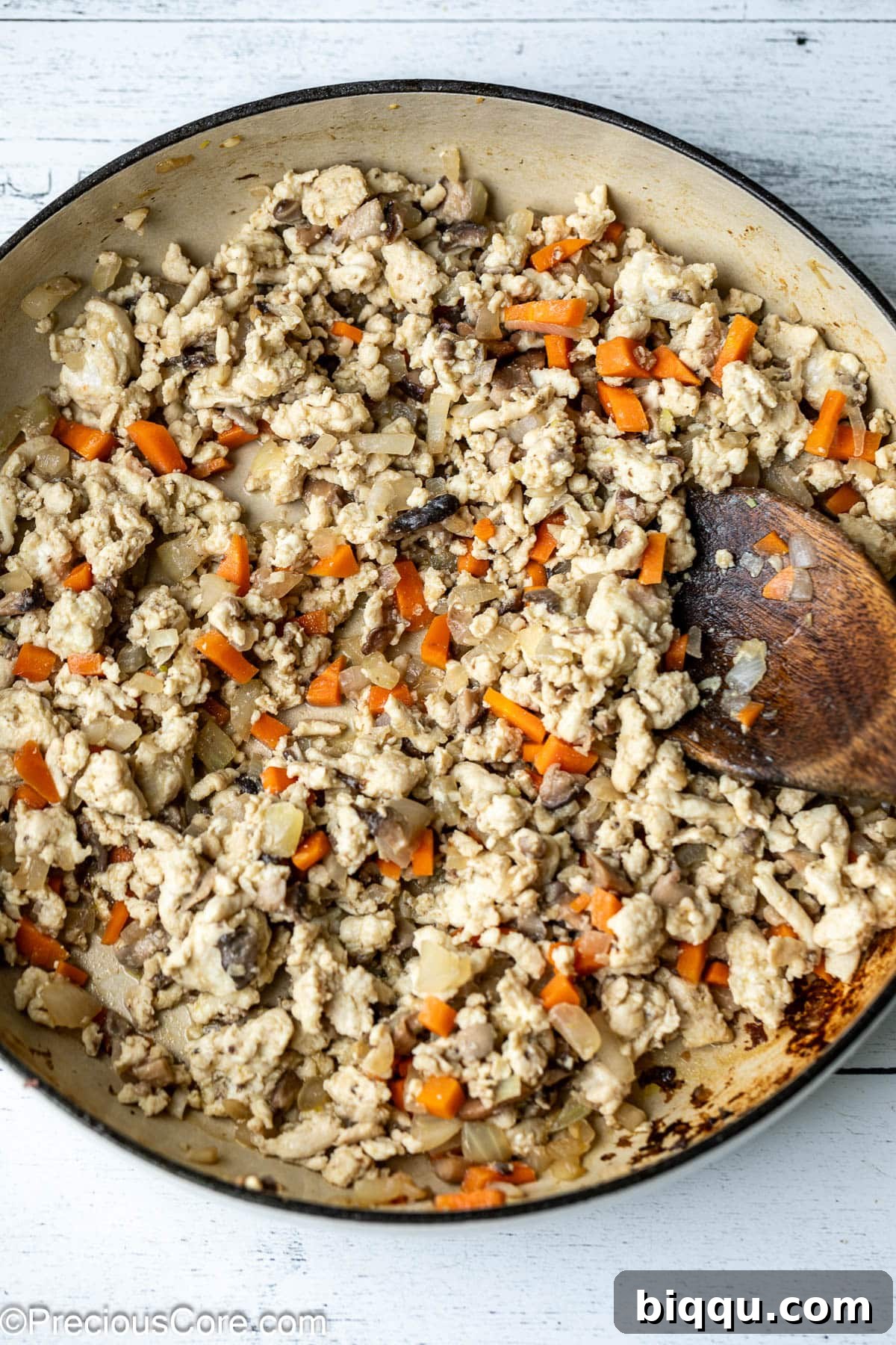 Ground chicken is cooked and crumbled in a pot with sautéed vegetables, showing no pink and ready for the next step of sauce preparation.