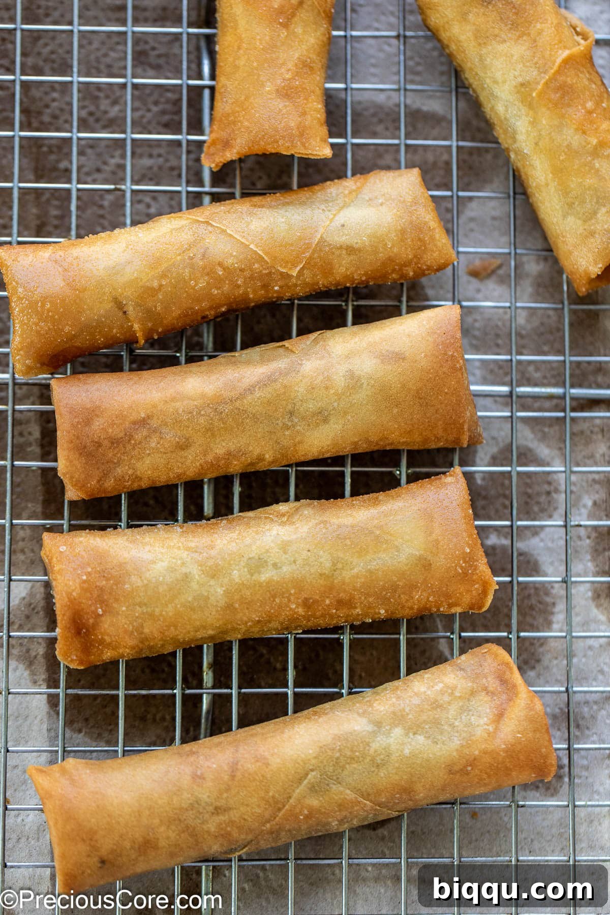 Savory Beef Spring Rolls 12 Deep fried rolls cooling on a wire rack over paper towels.